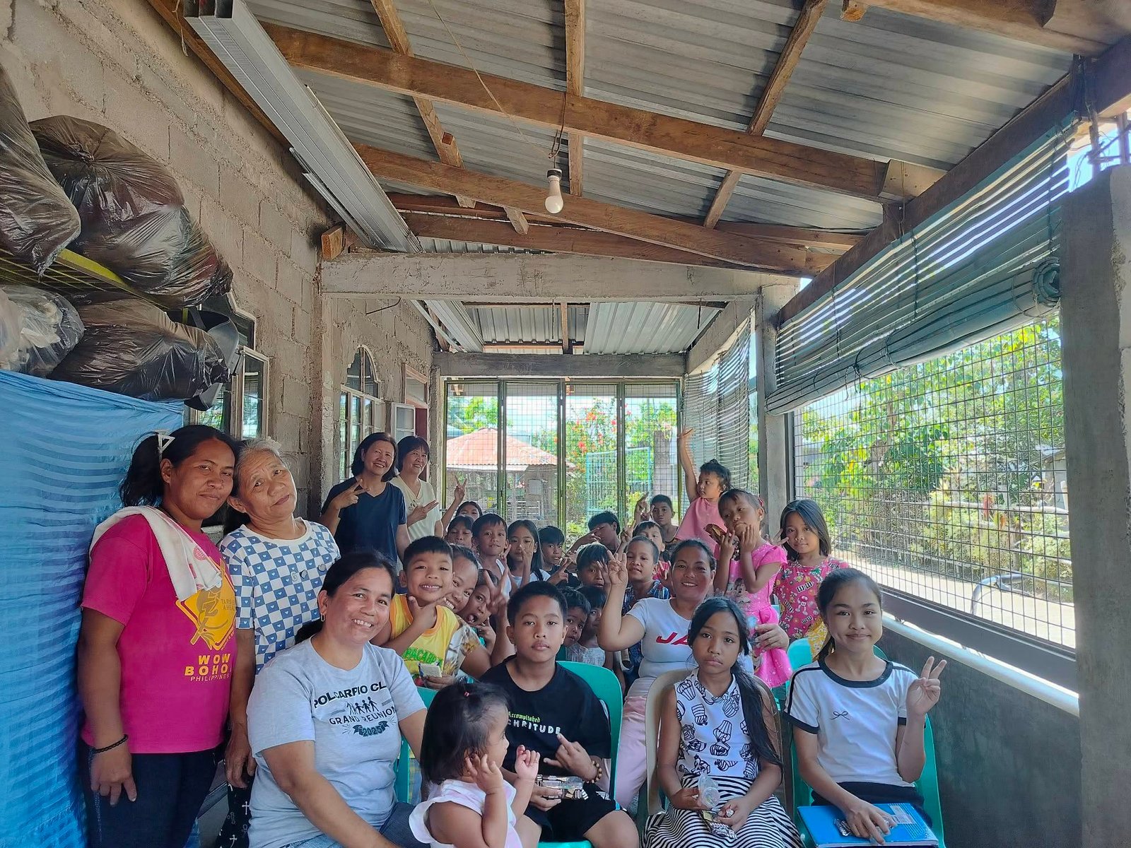 Children, mothers, and grandmothers gathered together at a community meeting place